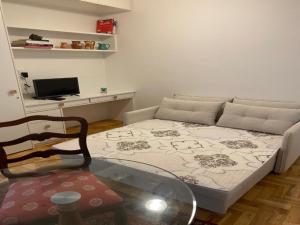 ein Wohnzimmer mit einem Bett und einem Glastisch in der Unterkunft Vista lateral mar, rua tranquila e arborizada in Rio de Janeiro