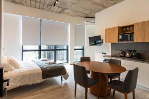 a bedroom with a bed and a table and chairs at Araucarias Apartamentos in Moreno