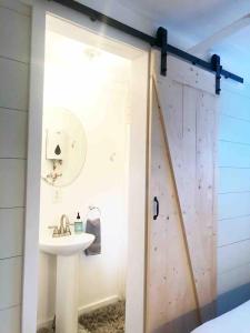 a bathroom with a sink and a sliding door at Camp Carter Tiny House in Mathias