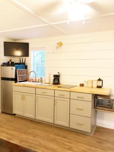 a kitchen with white cabinets and a sink at Camp Carter Tiny House in Mathias