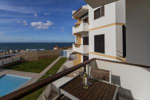 een balkon met een tafel en uitzicht op de oceaan bij Pérola do Mar in Foz do Arelho