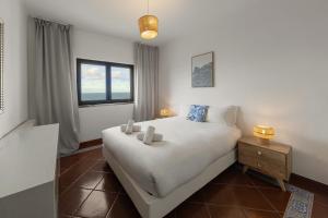 een slaapkamer met een groot wit bed en een raam bij Pérola do Mar in Foz do Arelho