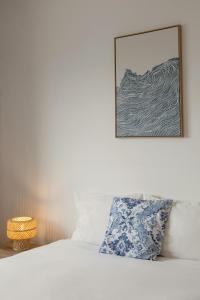 een bed met een foto op de muur erboven bij Pérola do Mar in Foz do Arelho