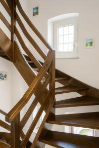 a wooden staircase in a room with a window at Dimora Donato 2 bedrooms Lauco UD in Lauco