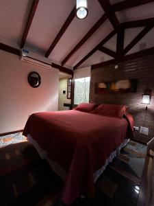 PurinkiWasi - La casa de todos في لوس ريترز: غرفة نوم بسرير كبير مع شراشف حمراء +15 صورة