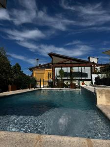 PurinkiWasi - La casa de todos في لوس ريترز: حمام سباحة مع شرفة بجوار منزل