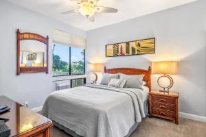 een slaapkamer met een bed en een raam bij Grand Champions 160 in Wailea
