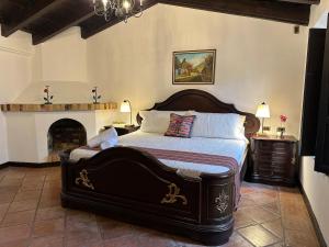 a bedroom with a large bed and a fireplace at Lovely house in Antigua Guatemala for 7 guests in Cataltzul