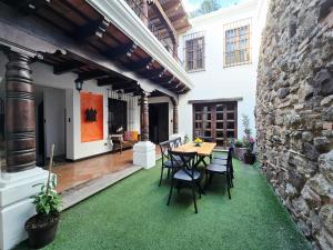 a patio with a table and chairs on grass at Lovely house in Antigua Guatemala for 7 guests in Cataltzul