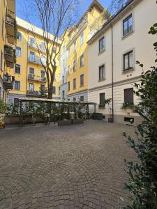 a courtyard in a building with benches and buildings at ArtStay Apt Sempione, Near Metro, City Centre in Milan