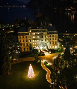 Un árbol de Navidad en un parque frente a un edificio en Lido Palace - The Leading Hotels of the World, en Riva del Garda