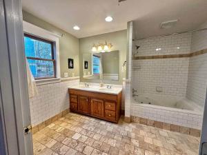 a bathroom with a tub and a sink and a tub and a mirror at Charming 3 bedroom Home in Decatur +24 photos