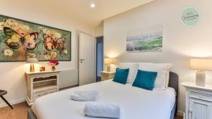 een slaapkamer met een groot wit bed met blauwe kussens bij Villa Boreal in Saint-Gilles-Croix-de-Vie