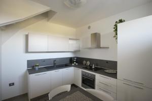 a kitchen with white cabinets and black counter tops at Residenza Verona New Life in Castel d'Azzano