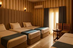 a hotel room with three beds and a window at Veda hotel in Cairo