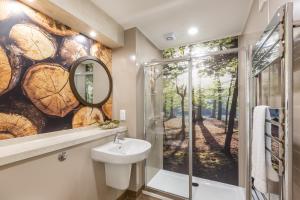 a bathroom with a wall mural of trees at Squirrel Lodge 43 with Hot Tub in Newton Stewart +17 photos