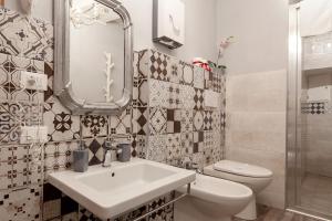 un bagno con lavandino, WC e specchio di Divas Rooms a Riomaggiore Altre 32 foto