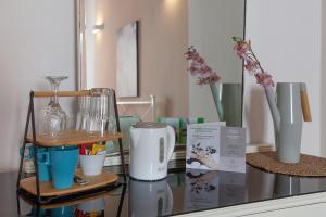 un ripiano in vetro con macchinetta del caffè e vasi di Divas Rooms a Riomaggiore