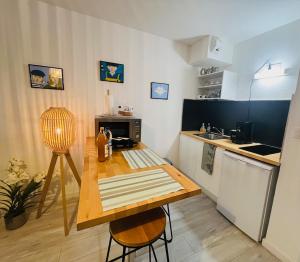 a small kitchen with a wooden table and a counter at Au bord de l'eau in Concarneau