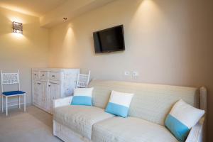 un salon avec un canapé et une télévision au mur dans l'établissement Sogno, à Tortolì