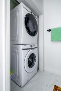 a washing machine is stacked on top of a washer at Jungle House Luxury Homes - Columbus Downtown Short North - Steps to Convention Center & Nationwide Arena - Sleeps up to 10 - Free Parking - Over 5,800 Five Stars in Columbus