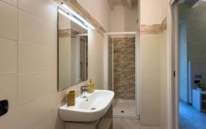 a white bathroom with a sink and a mirror at BelSorrisoVarese - Rooms & Apartments - Private Parking - Reservation Required in Varese +58 photos