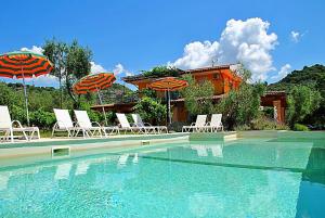 een zwembad met stoelen en parasols naast een huis bij Villa Meridiana in Itri