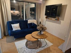 The Nut House - Cozy Escape in Tartu في Soinaste: غرفة معيشة مع أريكة زرقاء وطاولة