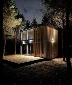 The Nut House - Cozy Escape in Tartu في Soinaste: منزل بواجهة خشبية في الليل