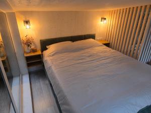 The Nut House - Cozy Escape in Tartu في Soinaste: سرير كبير في غرفة نوم مع مواقف ليلتين +3 صور