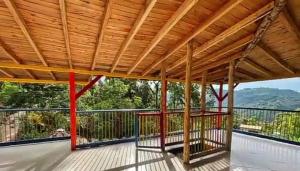 a porch with a wooden roof with a swing at Paisa Territory Lodge in Jardin