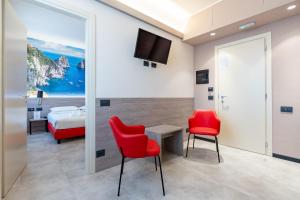 ein Zimmer mit zwei roten Stühlen und einem Bett in der Unterkunft Jet Hotel, Sure Hotel Collection by Best Western in Gallarate