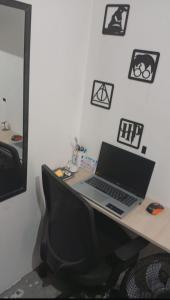 a desk with a laptop computer on top of it at Apartamento Serena in Votorantim