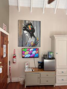 Caye Caulker Boutique Guesthouse 7 في كاي كولكر: غرفة فيها لوحة لامرأة على جدار