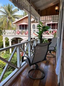 Caye Caulker Boutique Guesthouse 7 في كاي كولكر: كرسيين على شرفة المنزل +9 صور