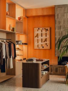 Un vestidor con paredes naranjas y armarios de madera. en Aethos London Shoreditch, en Londres