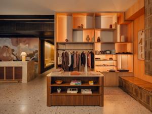 Una habitación con una vitrina con ropa en los estantes. en Aethos London Shoreditch, en Londres