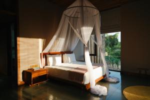 a bedroom with a canopy bed with a window at Kizikula - Boutique Hotel in Kizimkazi +201 photos