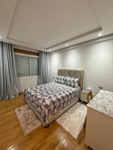 a bedroom with a bed and two rugs at Apartment luxurious a Hay Riad in Rabat +13 photos