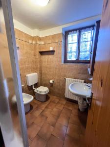 a bathroom with a toilet and a sink at Casa Vacanze Ca' De Val in Campodolcino +39 photos