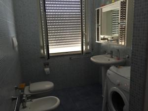 サン・ニコーラ・アルチェッラにあるCasello sul Mareのバスルーム(洗面台、トイレ付)、窓が備わります。