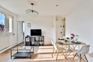 ピエール・ベニットにあるAppartement de charme, proche de toutes commoniditésのテーブルと椅子とテレビのあるリビングルーム