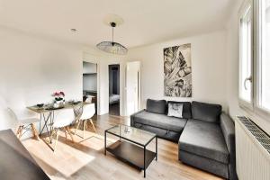 ピエール・ベニットにあるAppartement de charme, proche de toutes commoniditésのソファとテーブルのあるリビングルーム