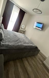 a bedroom with a bed and a tv on the wall at Luxury Apartment private parking in Craiova +8 photos