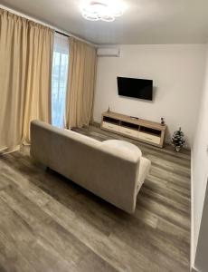 a living room with a couch and a flat screen tv at Luxury Apartment private parking in Craiova