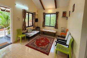 uma sala de estar com cadeiras verdes e um sofá em Gulmohar Villa tamhini ghat, Kolad Rafting 