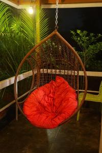 uma almofada vermelha em um balanço de vime em Gulmohar Villa tamhini ghat, Kolad Rafting 