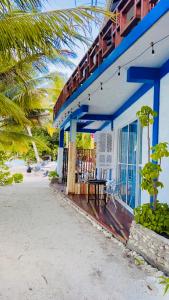 Nautical Nook Maldives في Kendhoo: منزل على الشاطئ مع طاولة على الشرفة