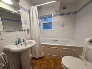 a bathroom with a sink and a tub and a toilet at Thin End in Seaview +22 photos