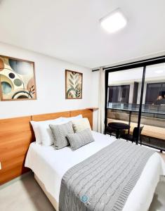 um quarto com uma cama e uma janela grande em Hit Cabo Branco by 123Quarto em Tambaú mais 66 fotografias